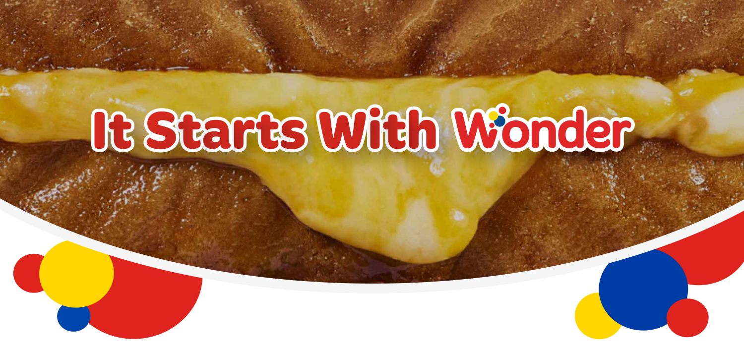 Bread with cheese and text 'It Starts With Wonder'